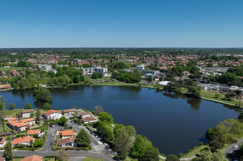 Vue aérienne d'une commune des Landes, zones bâties, lac et espaces naturels